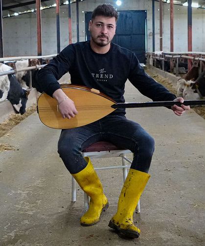 Besici kurbanlık hayvanlarına saz çalıp, türkü söylüyor