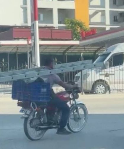 İlginç yolculuk kamerada: Boynunda merdivenle motosikletle ilerledi