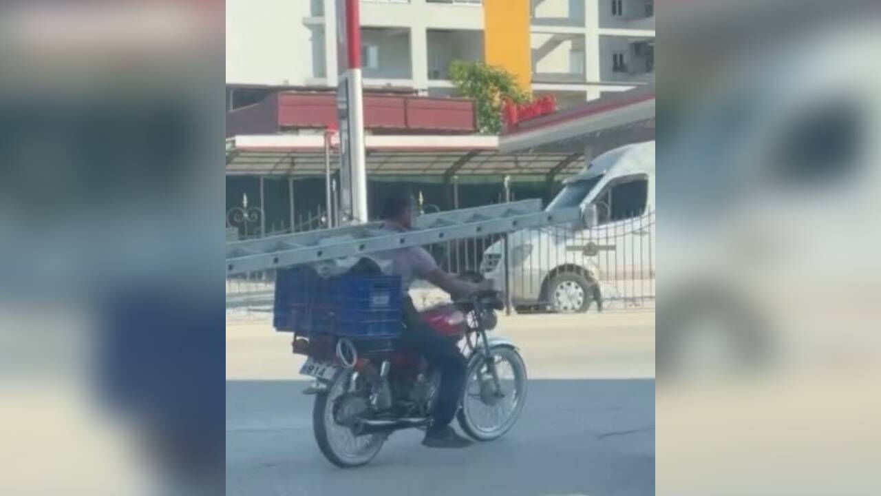 İlginç yolculuk kamerada: Boynunda merdivenle motosikletle ilerledi